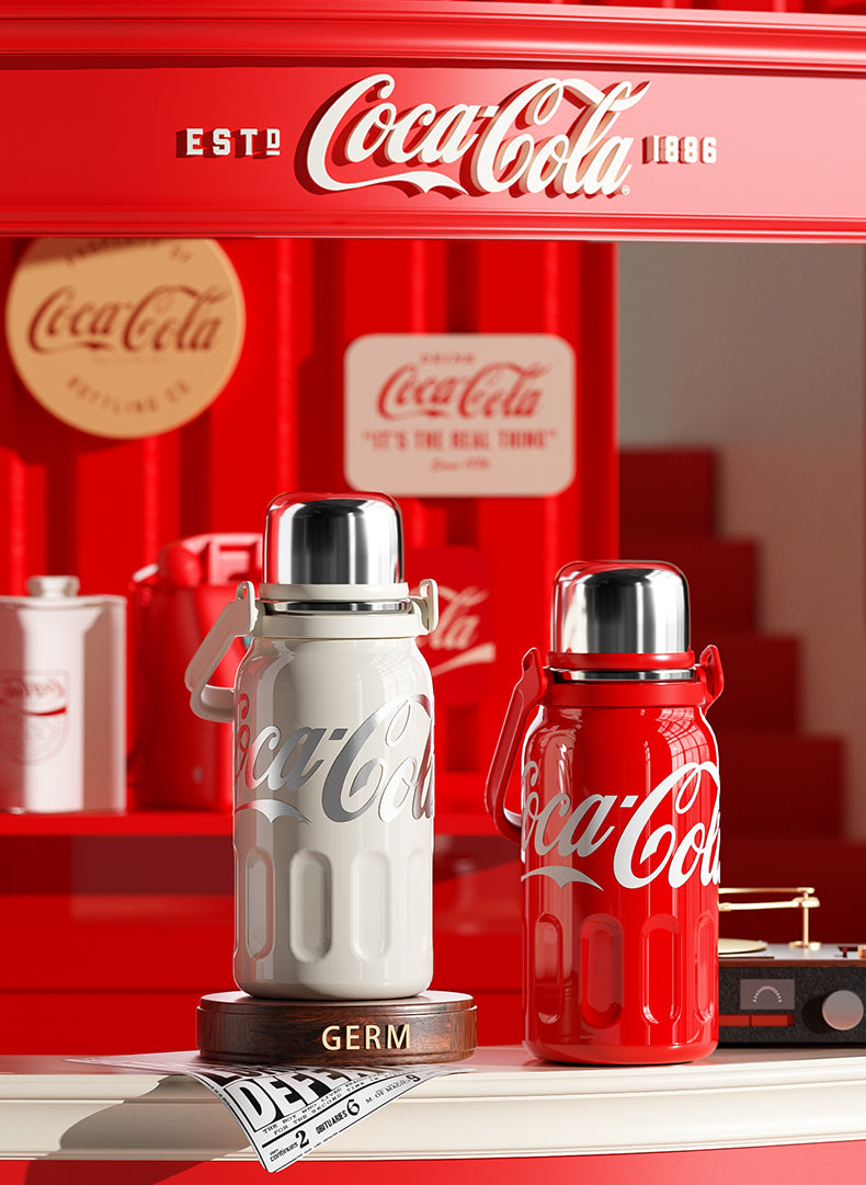 Two Coca-Cola thermos bottles on a red background with vintage Coca-Cola branding.
