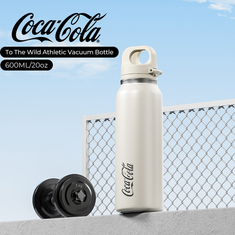 Coca-Cola athletic vacuum bottle with dumbbells against a blue sky background
