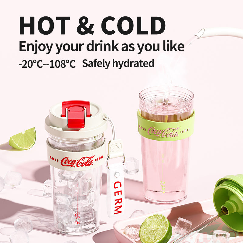 Coca-Cola water bottle with pink drink and lime slices on a white background