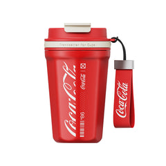 Red Coca-Cola tumbler with strap on a white background