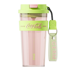 Pink tumbler with green lid and strap featuring Coca-Cola branding on a white background